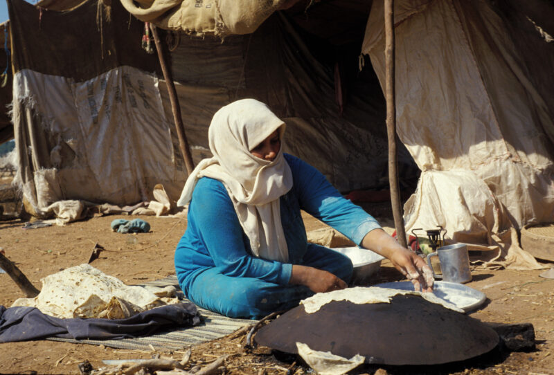 Making Flat Bread — Woman makes flatbread over a wood fire on her Taboon by her tent — Jordan, woman, cooking, food, bread