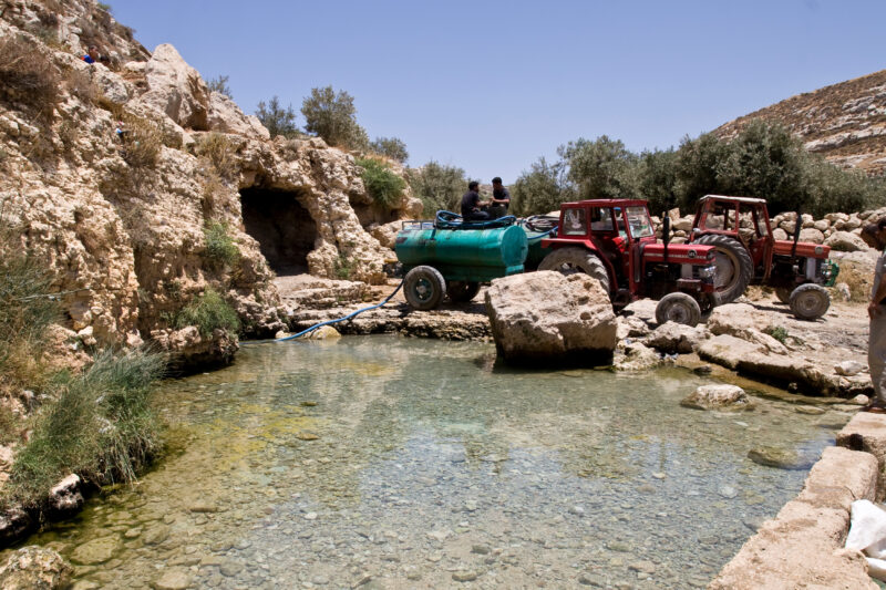 Filling Water containers for Agriculture in Jordan — Men pump tanks full of water to distribute to fields for growing vegetables. — Archaeology, Jordan, wate...