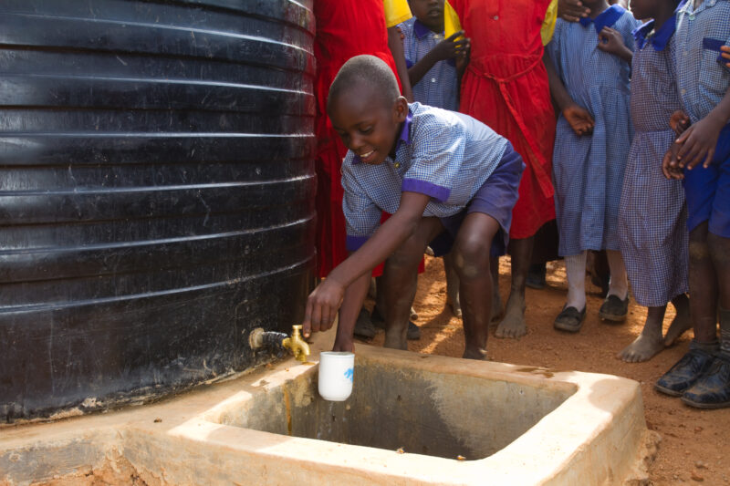 Water at School — In a remote rural school in Kenya, students enjoy the convenience of drinking water from a storage tank provided by ADRA, located right out...