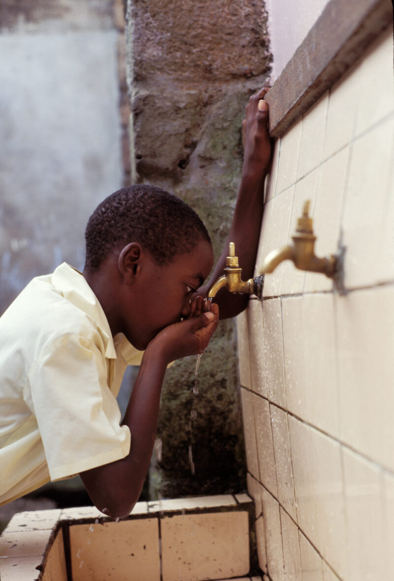 Getting a Drink in Dominica — Boy gets a refreshing drink from the gravity fed water tap that has been installed at his school by ADRA — Child, Boy, student,...