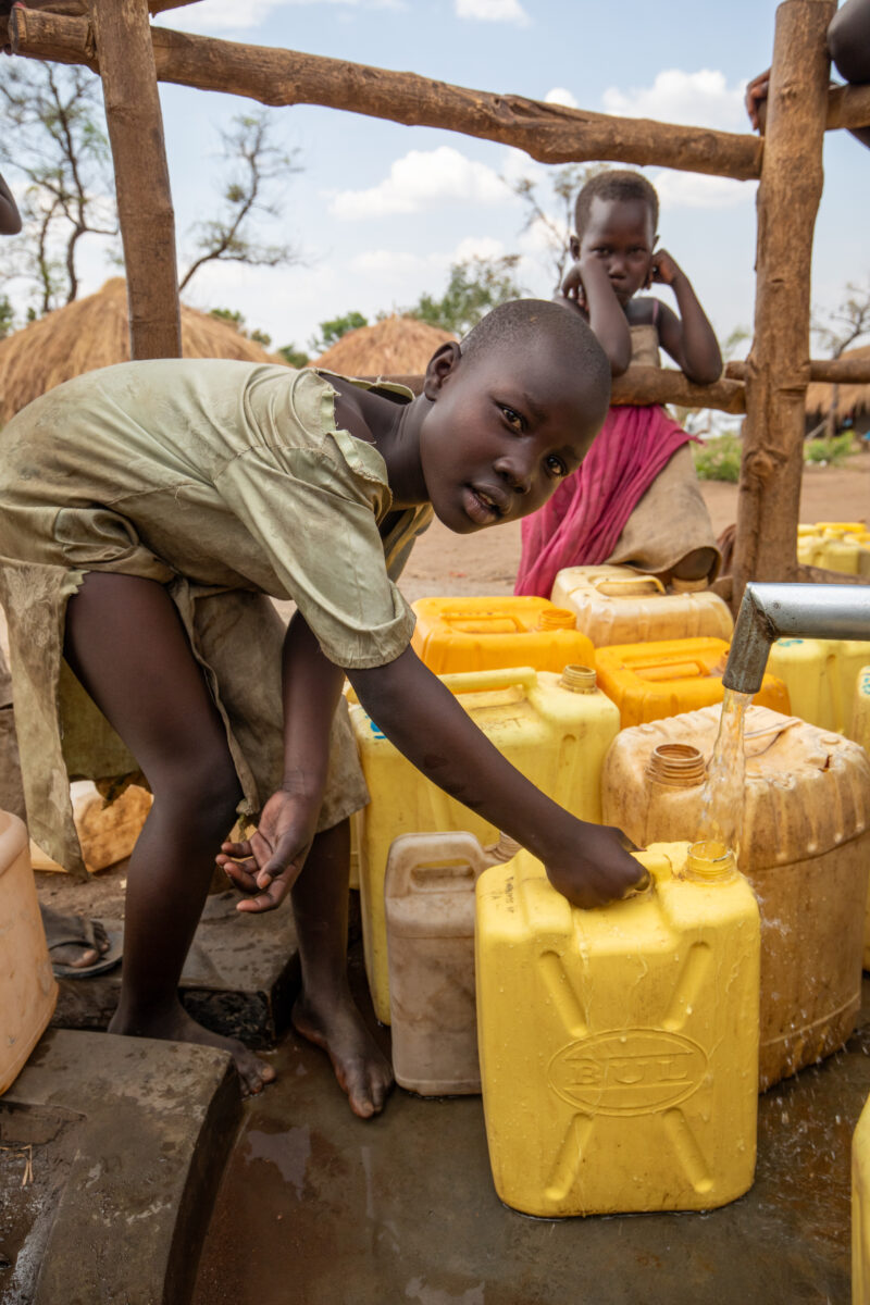 Collecting Water in the Refugee Settlement — Refugee girl collects water in her new home at a Refugee Settlement in Uganda — Adult, Boat, Canoe, Child, Eyes ...