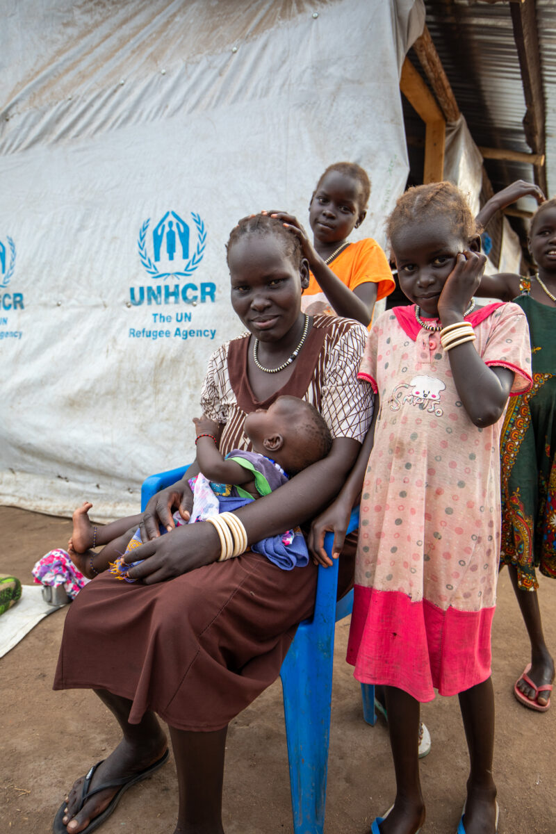 Arriving in Uganda — After fleeing their homeland, refugees arrive in Uganda. — Adult, Beard, Boat, Child, Eyes Open