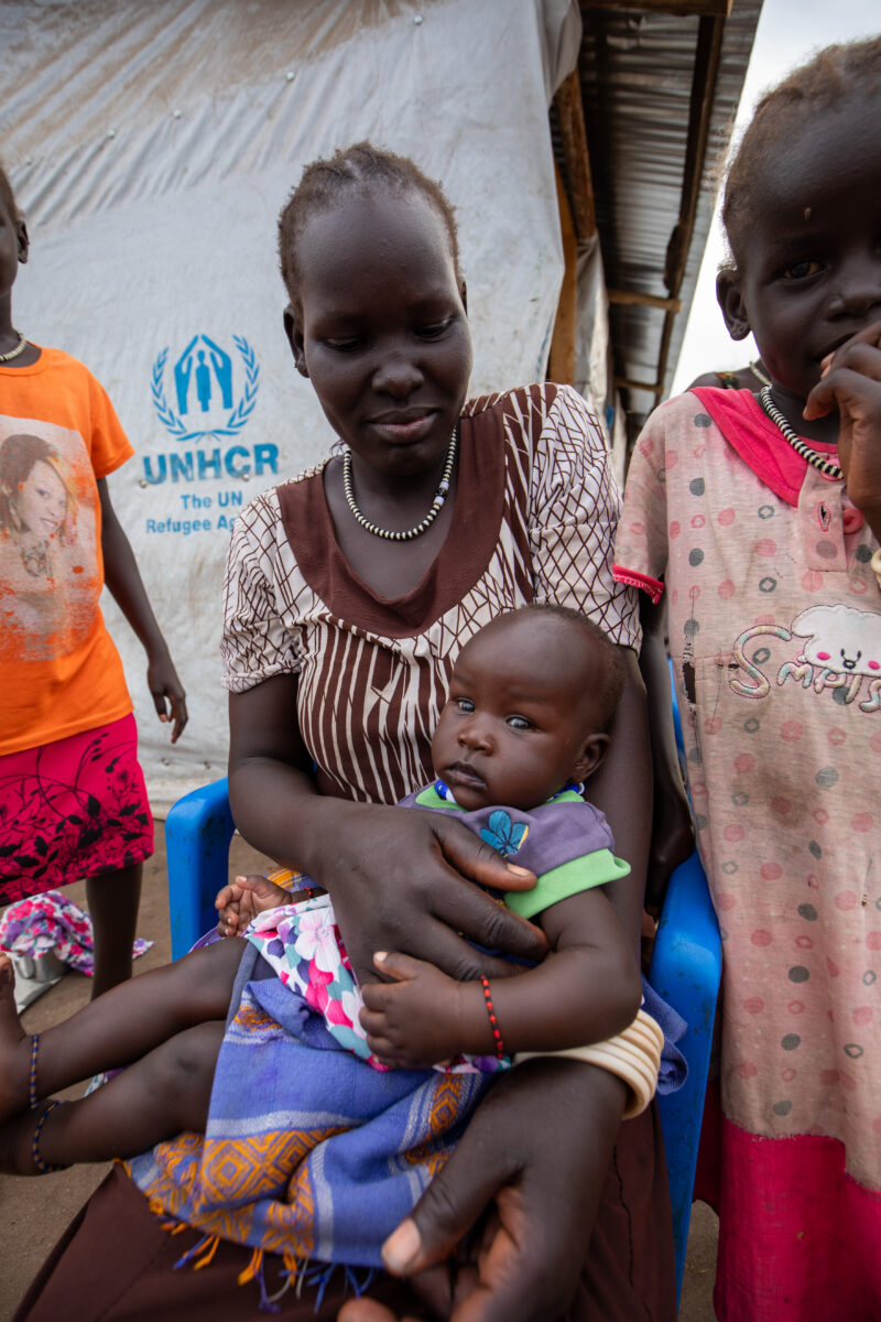 Arriving in Uganda — After fleeing their homeland, refugees arrive in Uganda. — Adult, Baby, Eyes Closed, Eyes Open, Female