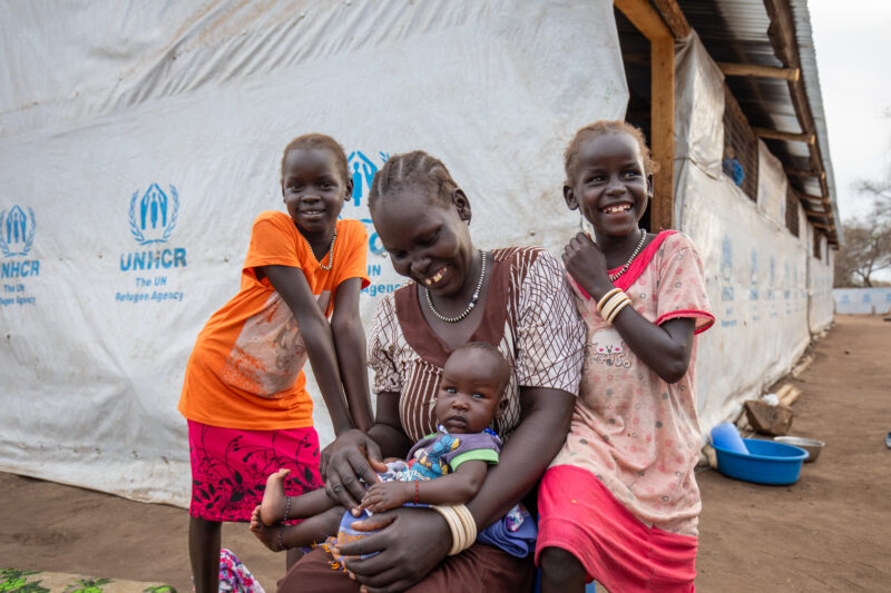 Arriving in Uganda — After fleeing their homeland, refugees arrive in Uganda. — Adult, Baby, Boat, Child, Eyes Closed