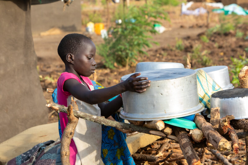 Washing Dishes — Young refugee girl washes dishes in her new home in Uganda. — Boat, Canoe, One Face, Person, Portrait