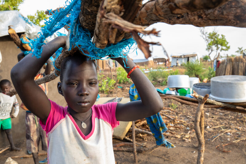 Collecting Firewood — Refugee child collects firewood for cooking. — Child, Eyes Open, Frontal Face, Person, Profile Face