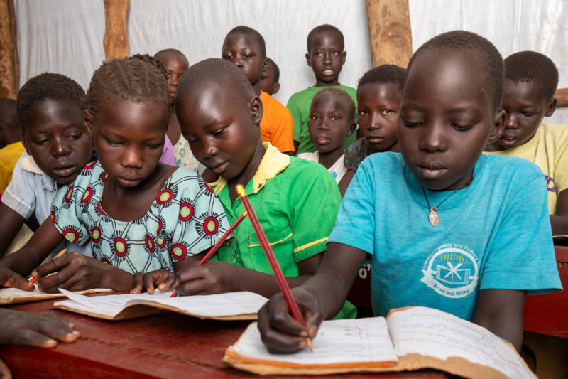 School in the Refugee Settlement — Refugee Children attend school at the refugee settlement they call their new home. — Adult, Child, Eyes Closed, Eyes Open,...