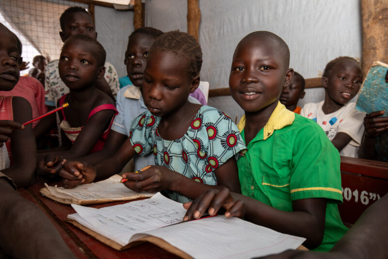 School in the Refugee Settlement — Refugee Children attend school at the refugee settlement they call their new home. — Child, Eyes Open, Female, Frontal Fac...