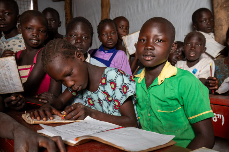 School in the Refugee Settlement — Refugee Children attend school at the refugee settlement they call their new home. — Adult, Beard, Child, Eyes Open, Female