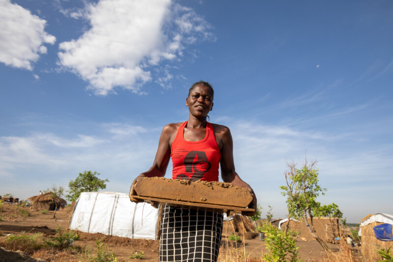 Making Bricks — South Sudan refugee woman makes mud bricks for the house that she is building at the refugee setllement. — Complementary Colors, Eyes Open, F...