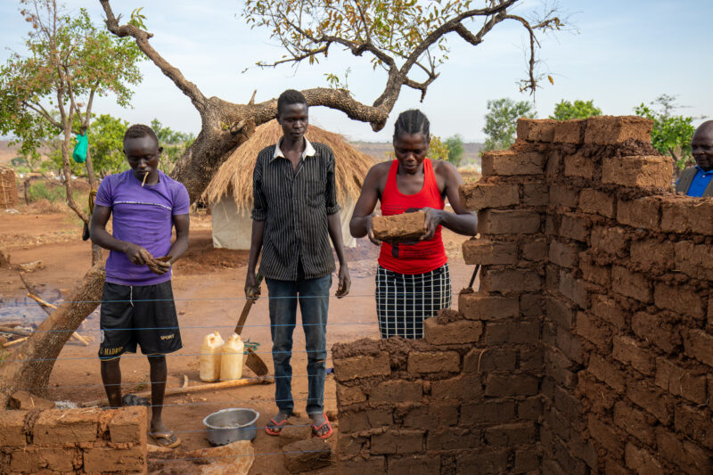 Building a House — Refugees from South Sudan build a small house in the Refugee Settlement that have been invited to by Uganda. — Adult, Eyes Closed, Eyes Op...
