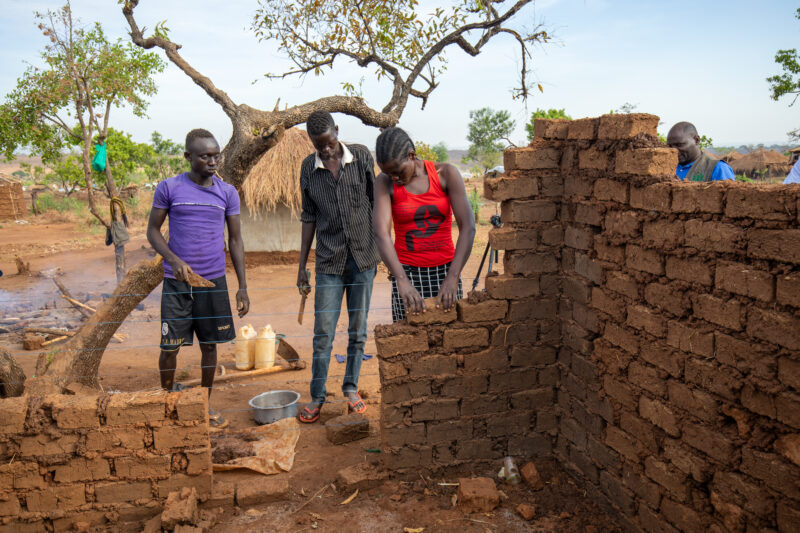 Building a House — Refugees from South Sudan build a small house in the Refugee Settlement that have been invited to by Uganda. — Adult, Brick Texture, Eyes ...