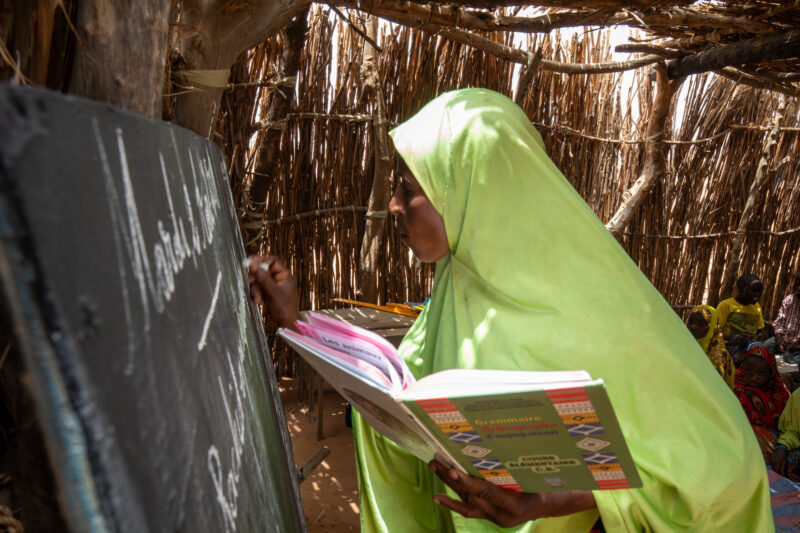Temporary Classroom — Students in Niger, Africa, attend school in a classroom made of mud and sticks. — Africa, Education, Niger, Text