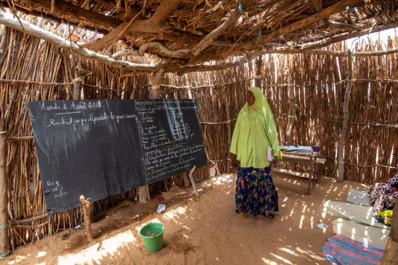 Temporary Classroom — Students in Niger, Africa, attend school in a classroom made of mud and sticks. — Adult, Africa, Beard, Education, Eyes Open