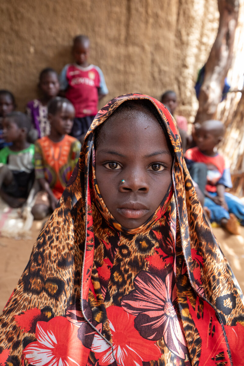 Temporary Classroom — Students in Niger, Africa, attend school in a classroom made of mud and sticks. — Africa, Close-Up, Education, Eyes Open, Female