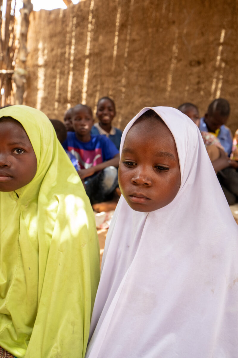 Temporary Classroom — Students in Niger, Africa, attend school in a classroom made of mud and sticks. — Africa, Education, Eyes Open, Female, Frontal Face