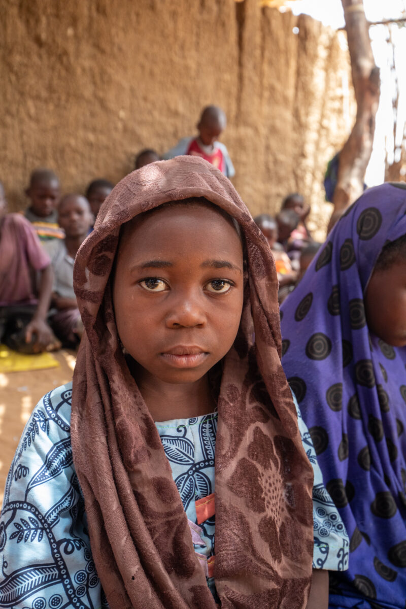 Temporary Classroom — Students in Niger, Africa, attend school in a classroom made of mud and sticks. — Africa, Child, Education, Eyes Open, Female