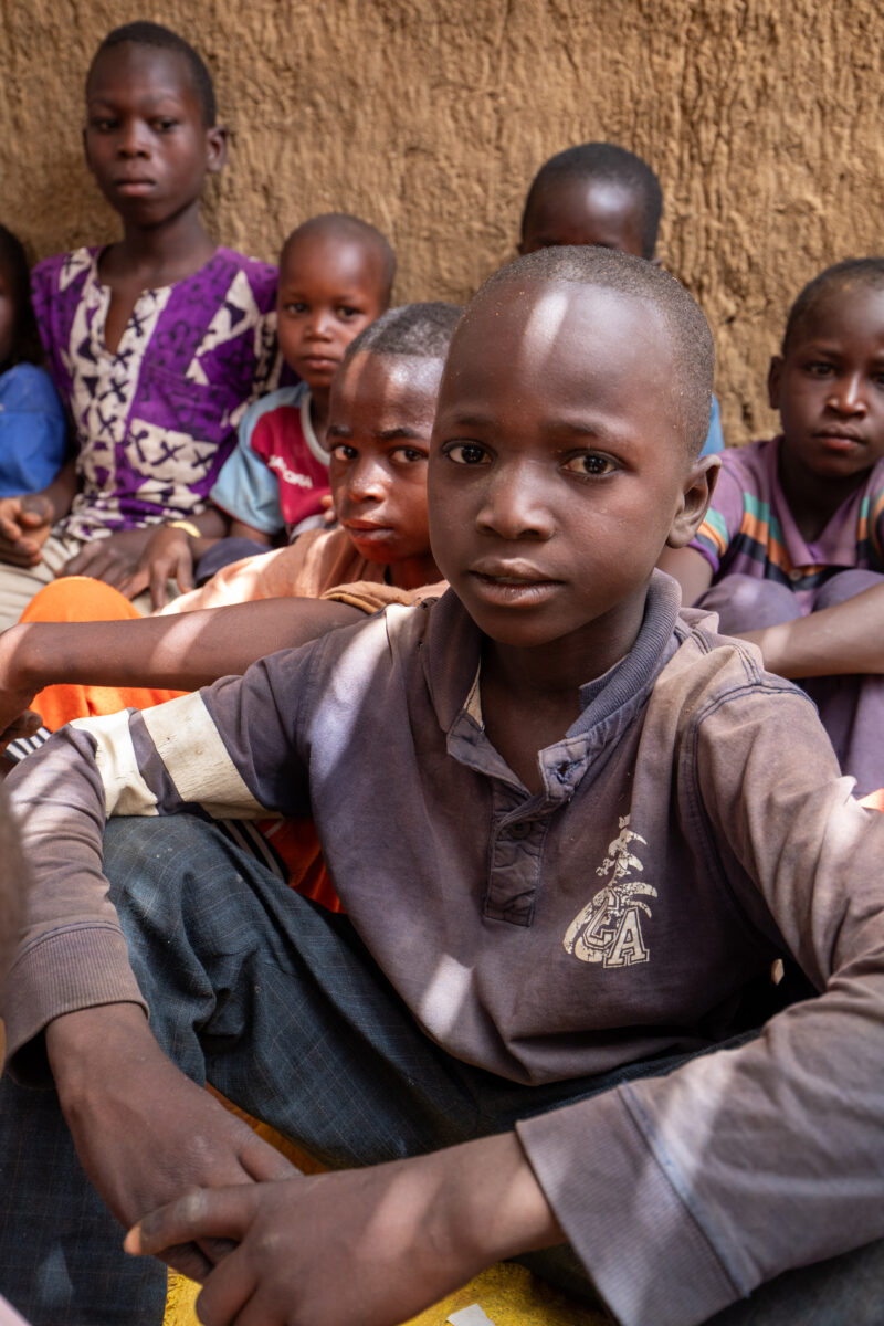 Temporary Classroom — Students in Niger, Africa, attend school in a classroom made of mud and sticks. — Africa, Child, Education, Eyes Closed, Eyes Open