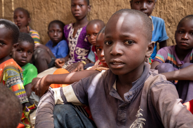 Temporary Classroom — Students in Niger, Africa, attend school in a classroom made of mud and sticks. — Adult, Africa, Child, Education, Eyes Closed