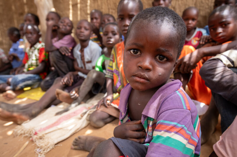 Temporary Classroom — Students in Niger, Africa, attend school in a classroom made of mud and sticks. — Adult, Africa, Child, Education, Eyes Closed