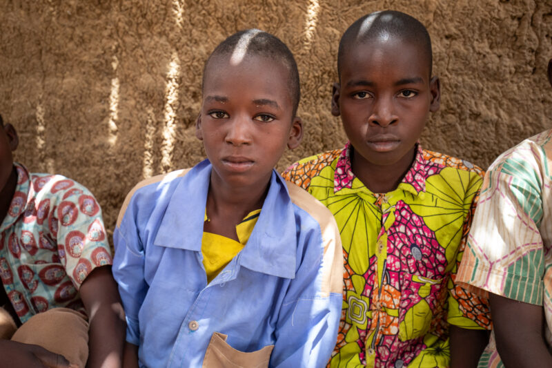 Temporary Classroom — Students in Niger, Africa, attend school in a classroom made of mud and sticks. — Africa, Education, Eyes Open, Female, Frontal Face