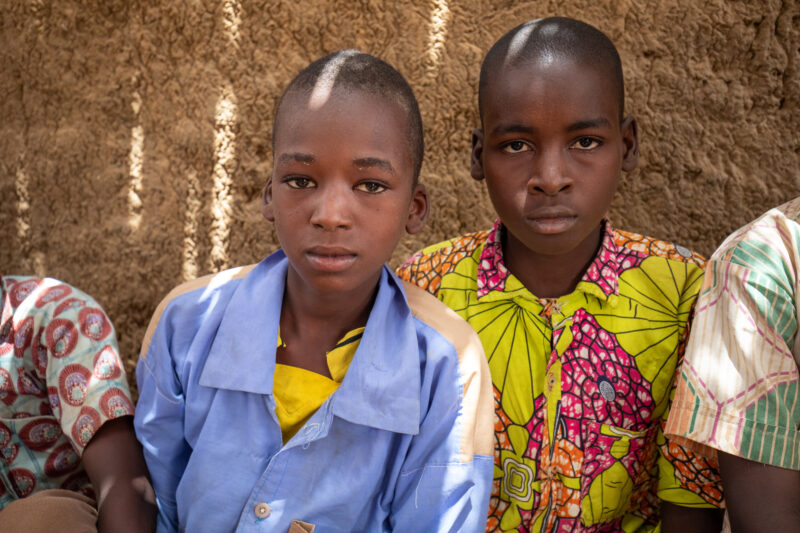 Temporary Classroom — Students in Niger, Africa, attend school in a classroom made of mud and sticks. — Africa, Child, Education, Eyes Open, Frontal Face