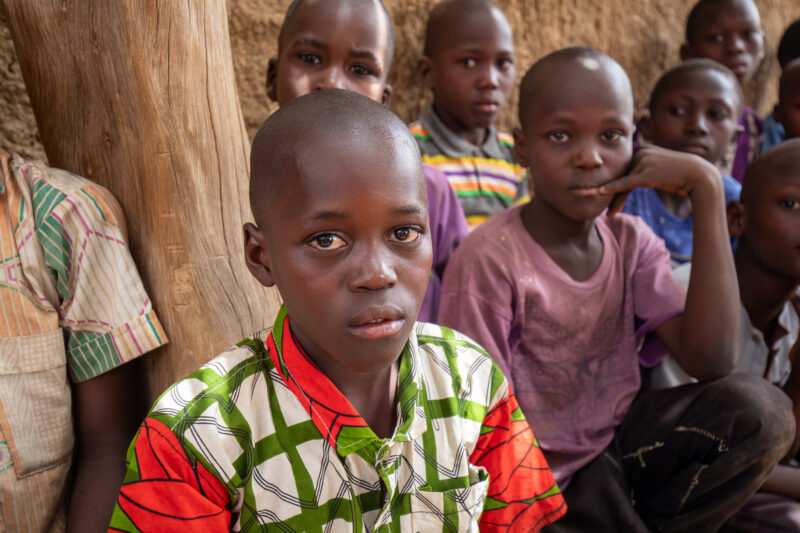Temporary Classroom — Students in Niger, Africa, attend school in a classroom made of mud and sticks. — Adult, Africa, Child, Education, Eyes Closed