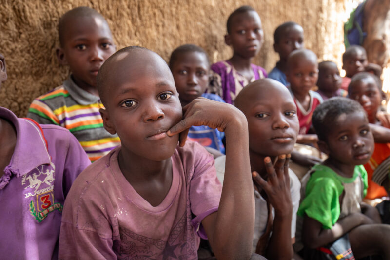 Temporary Classroom — Students in Niger, Africa, attend school in a classroom made of mud and sticks. — Adult, Africa, Child, Education, Eyes Closed