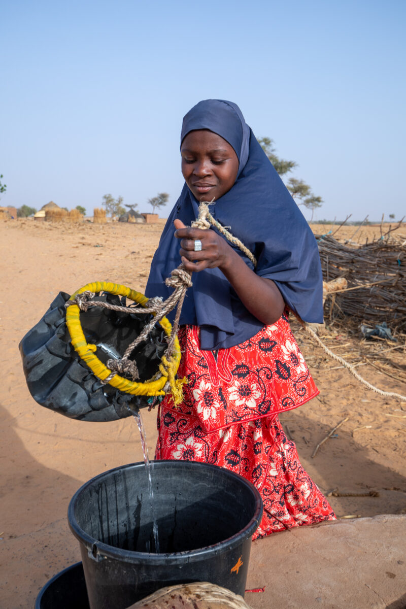 Collecting Water in Niger — A daily task in many regions of rural Africa is the trip to a water source to collect water. — Africa, Education, Eyes Closed, Fe...