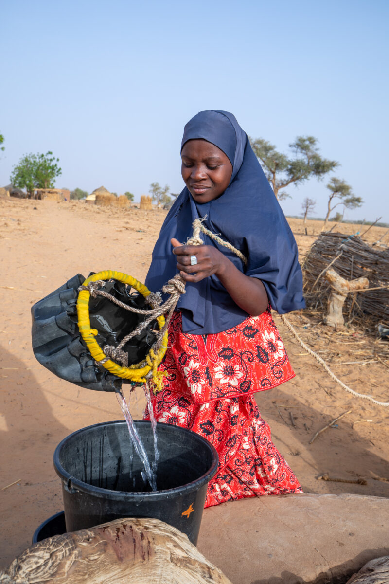 Collecting Water in Niger — A daily task in many regions of rural Africa is the trip to a water source to collect water. — Africa, Education, Eyes Closed, Fe...