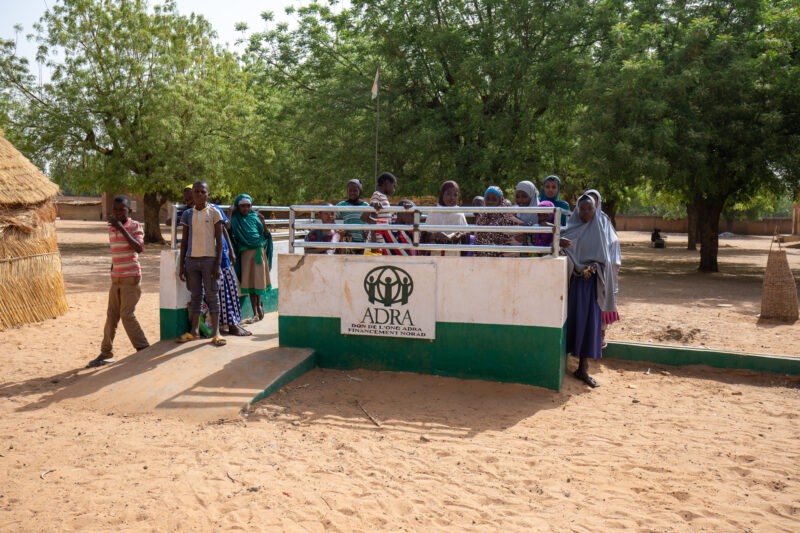 ADRA Well — Students get a refreshing drink at a well at their school provided by ADRA — Adult, Africa, Ball Game, Boat, Child