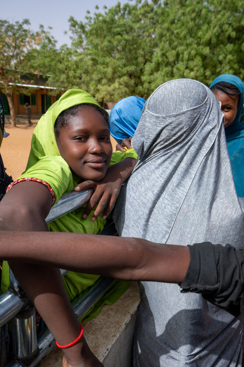 At the School Well — Students get a refreshing drink at a well at their school provided by ADRA — Africa, Child, Education, Eyes Open, Female