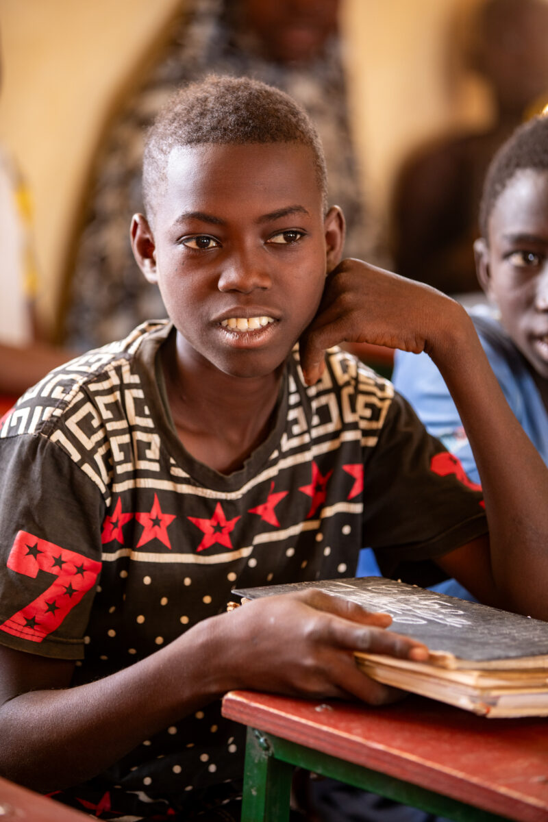 Boy in School in Niger — Young boy attends school in Niger, Africa — Africa, Blond Hair, Education, Eyes Open, Frontal Face