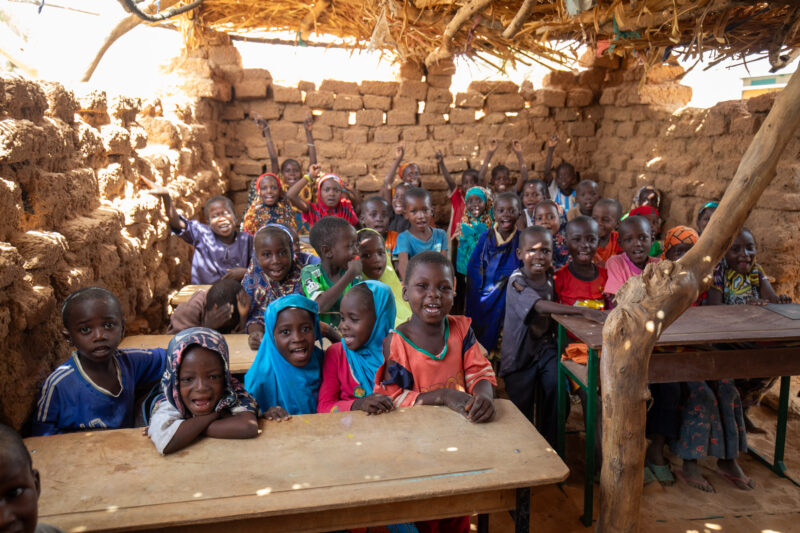 Temporary Classroom — Students in Niger, Africa, attend school in a classroom made of mud and sticks. — Adult, Africa, Child, Education, Eyes Closed