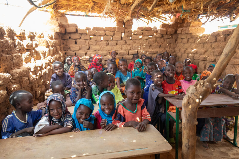 Temporary Classroom — Students in Niger, Africa, attend school in a classroom made of mud and sticks. — Adult, Africa, Child, Education, Eyes Closed