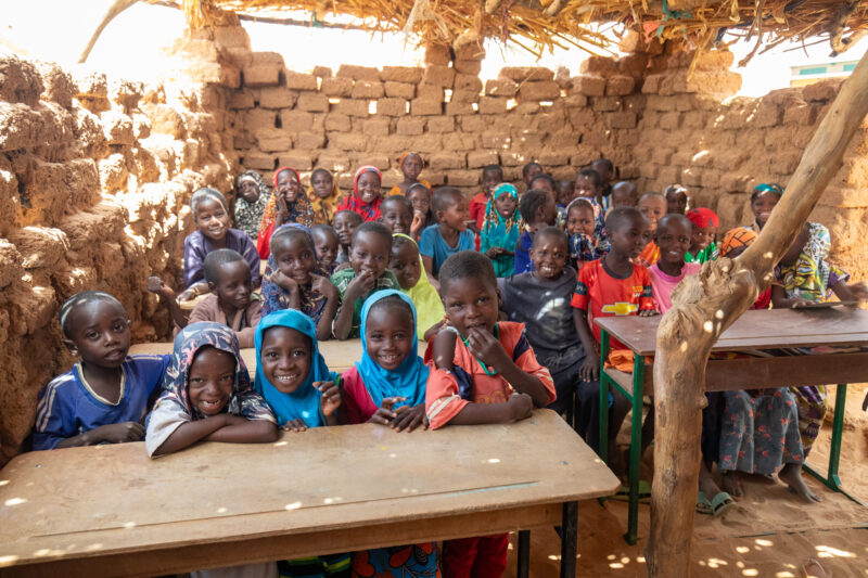 Temporary Classroom — Students in Niger, Africa, attend school in a classroom made of mud and sticks. — Adult, Africa, Beard, Child, Education