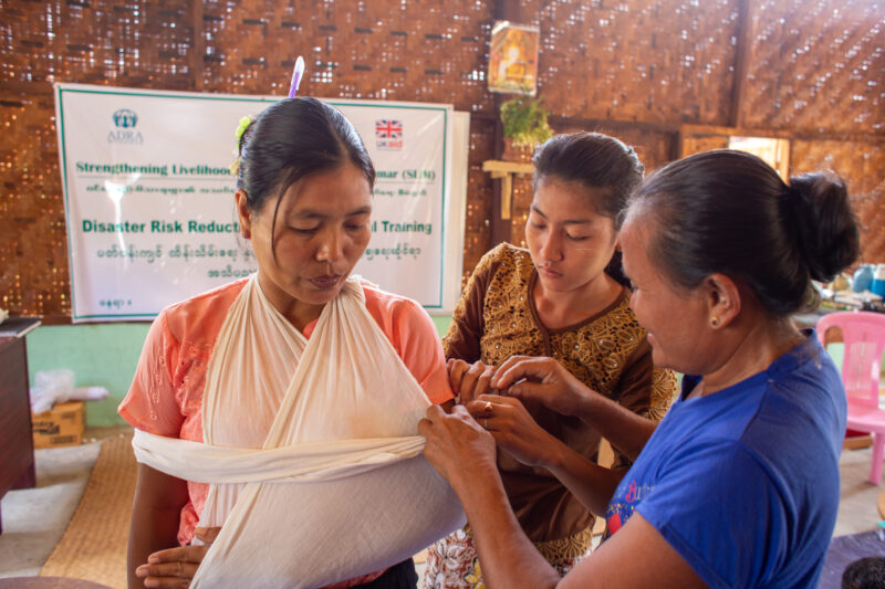 First Aid Training — People in Myanmar learn first aid. — Adult, Architecture, Building, Eyes Closed, Female