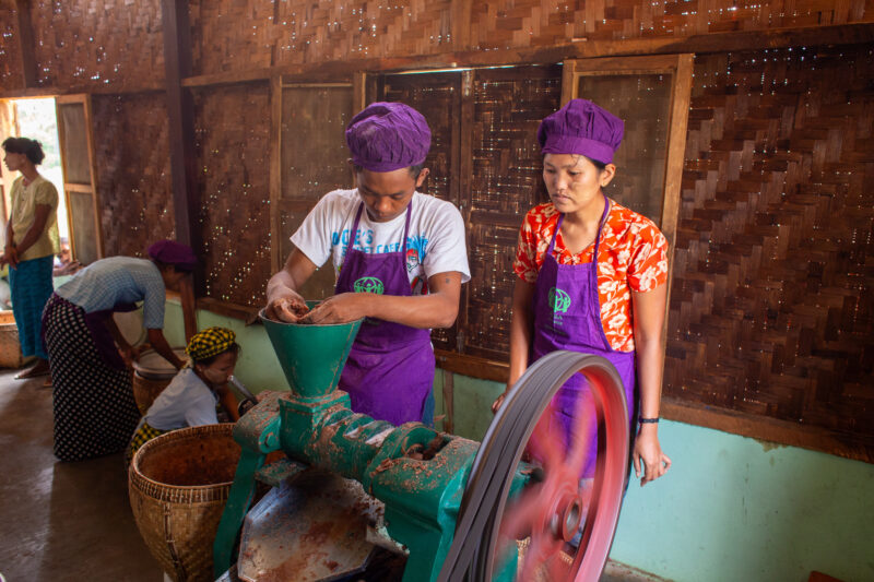 Making Peanutbutter — People in Rural Myanmar learn how to make peanutbutter as a way to create income. — Adult, Eyes Closed, Female, Frontal Face, Group
