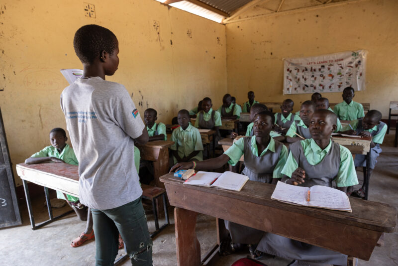 Teacher and Students in South Sudan — In rural villages in South Sudan, Children are going back to school. — Adult, Child, Eyes Open, Frontal Face, Group