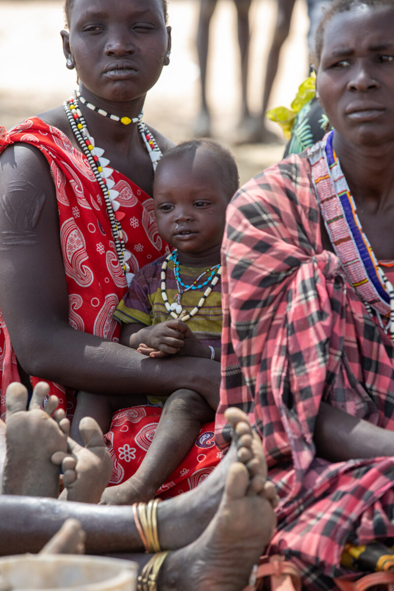 Adult Education — Adults under a tree gather for education on health, food security and income generation. — Adult, Child, Eyes Open, Frontal Face, Group