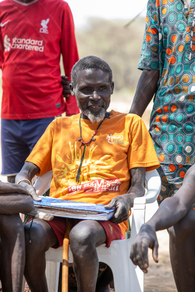 Adult Education — Adults under a tree gather for education on health, food security and income generation. — Adult, Beard, Boat, Eyes Open, Frontal Face