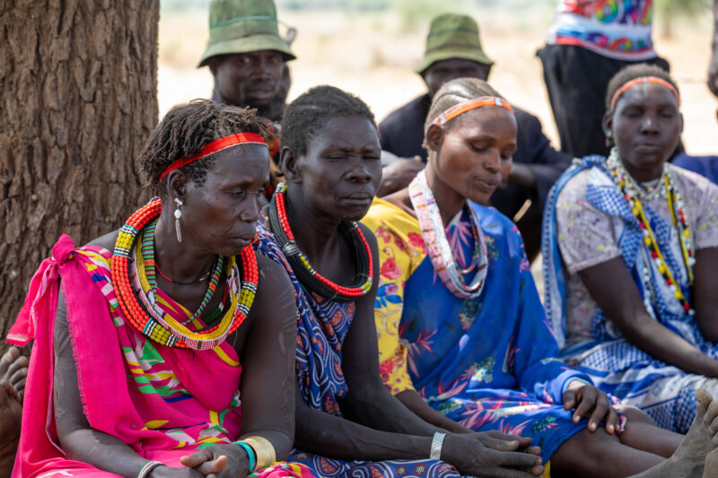 Adult Education — Adults under a tree gather for education on health, food security and income generation. — Adult, Beard, Eyes Closed, Female, Frontal Face