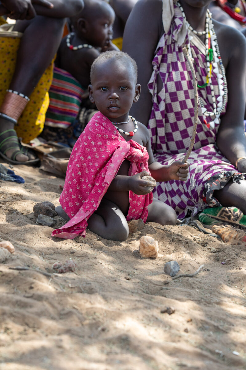 Adult Education — Adults under a tree gather for education on health, food security and income generation. — Child, Eyes Open, Frontal Face, Male, Person