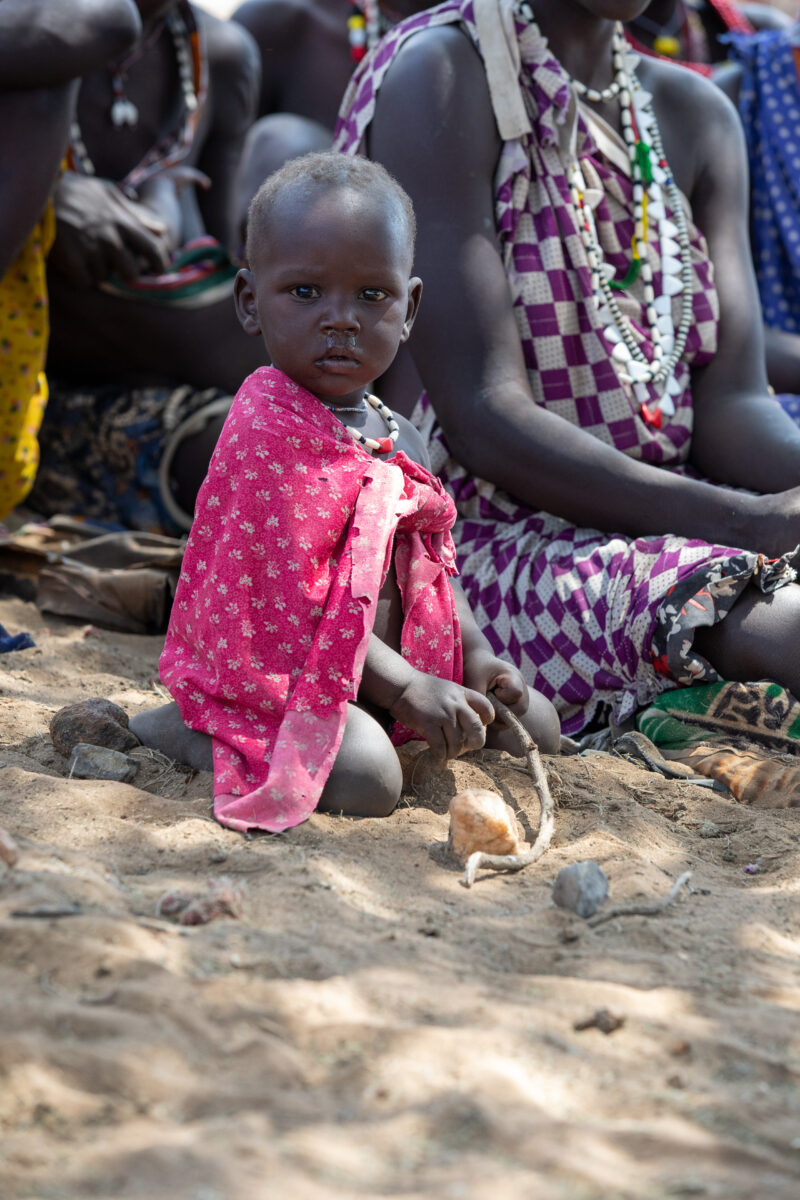 Adult Education — Adults under a tree gather for education on health, food security and income generation. — Child, Eyes Open, Female, Frontal Face, One Face