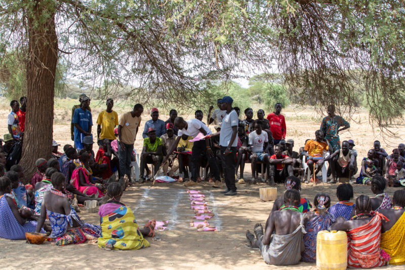Adult Education — Adults under a tree gather for education on health, food security and income generation. — Boat, Group, Person, Vehicle, Africa