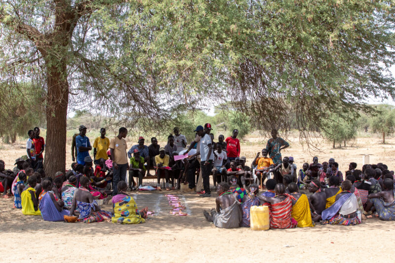Adult Education — Adults under a tree gather for education on health, food security and income generation. — Boat, Group, Person, Vehicle, Africa