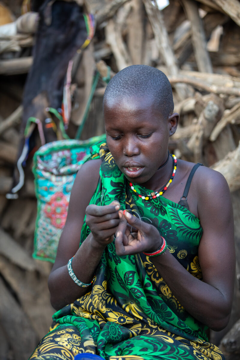 Bead Working in Africa — Young girl in South Sudan does beed work. — Adult, Eyes Closed, Frontal Face, One Face, Person