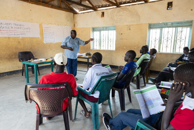 Teacher Training — Teachers go back to school to learn new methods of teaching in rural South Sudan. — Adult, Beard, Eyes Closed, Frontal Face, Group