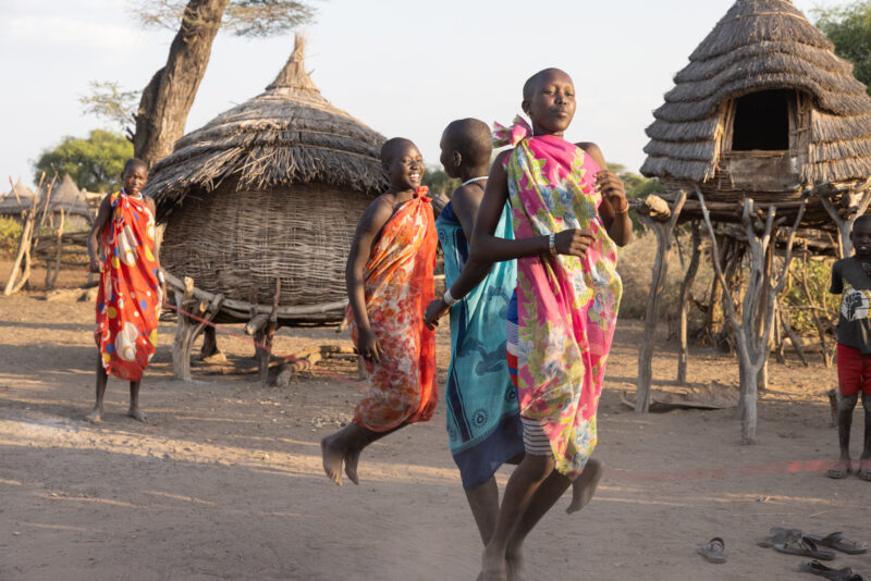 Skipping in Africa — Young girls in South Sudan Africa enjoy skipping in the evening light — Adult, Beard, Eyes Open, Female, Frontal Face