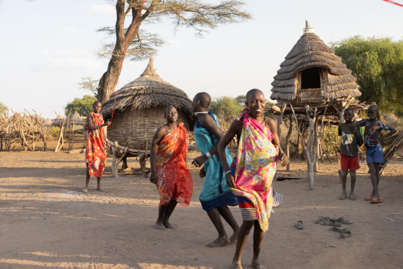 Skipping in Africa — Young girls in South Sudan Africa enjoy skipping in the evening light — Adult, Eyes Closed, Eyes Open, Frontal Face, Group